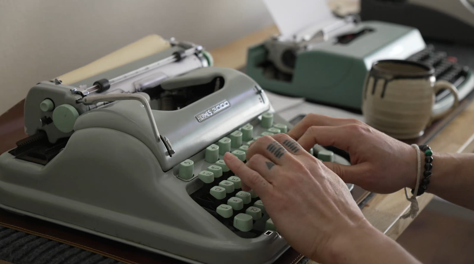 Hands typing on a vintage typewriter